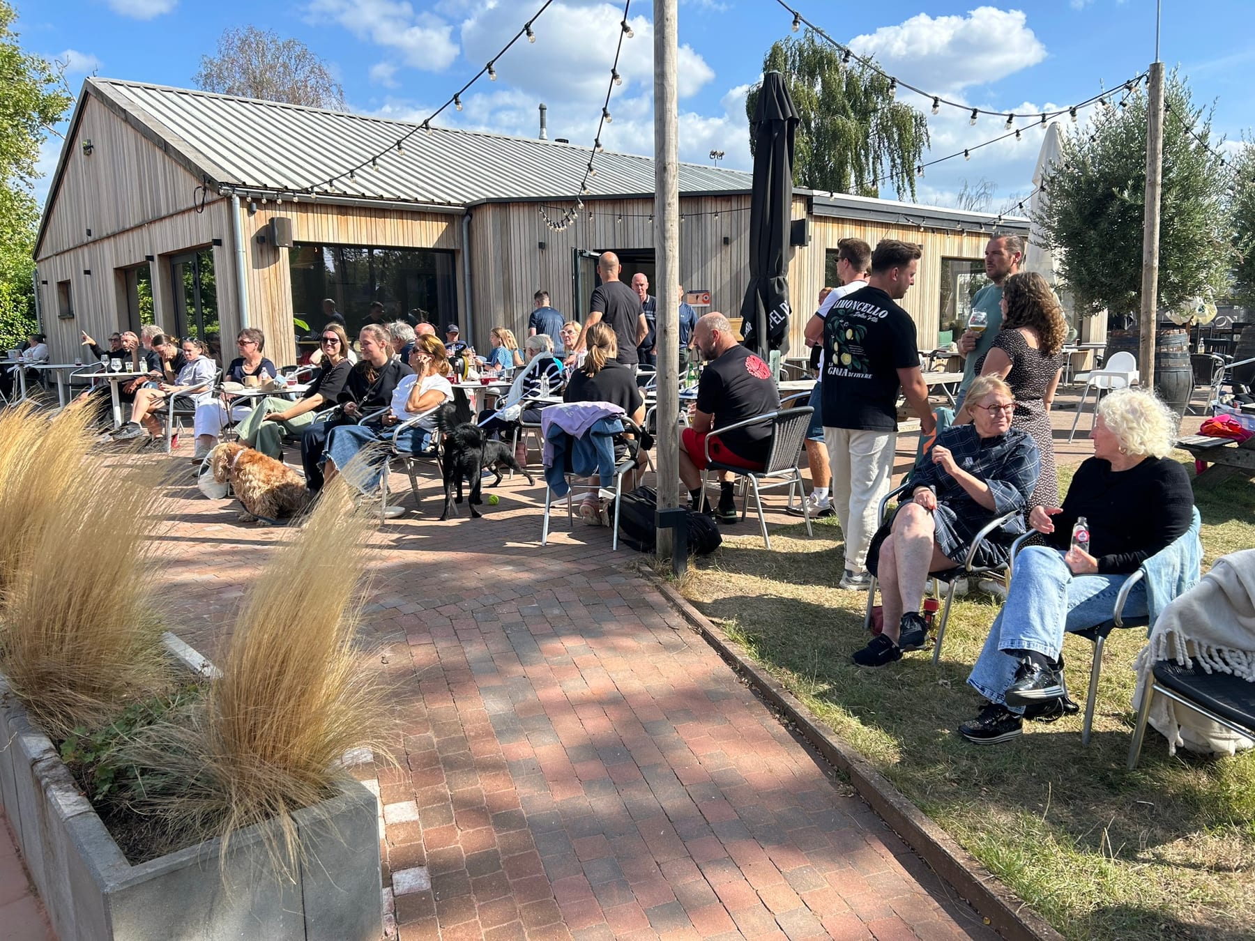 Een vol terras aan het clubhuis op een zonnige dag
